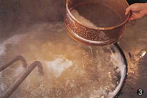 鉄鍋にあめの原液をいれて蒸気で煮つめていく。白いアクが次々と生まれるが、これをこまめに除いていく。これを怠ると不透明で雑味のあるあめになる。
